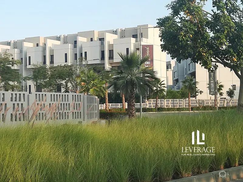 Townhouses behind landscaped grasses and palm trees